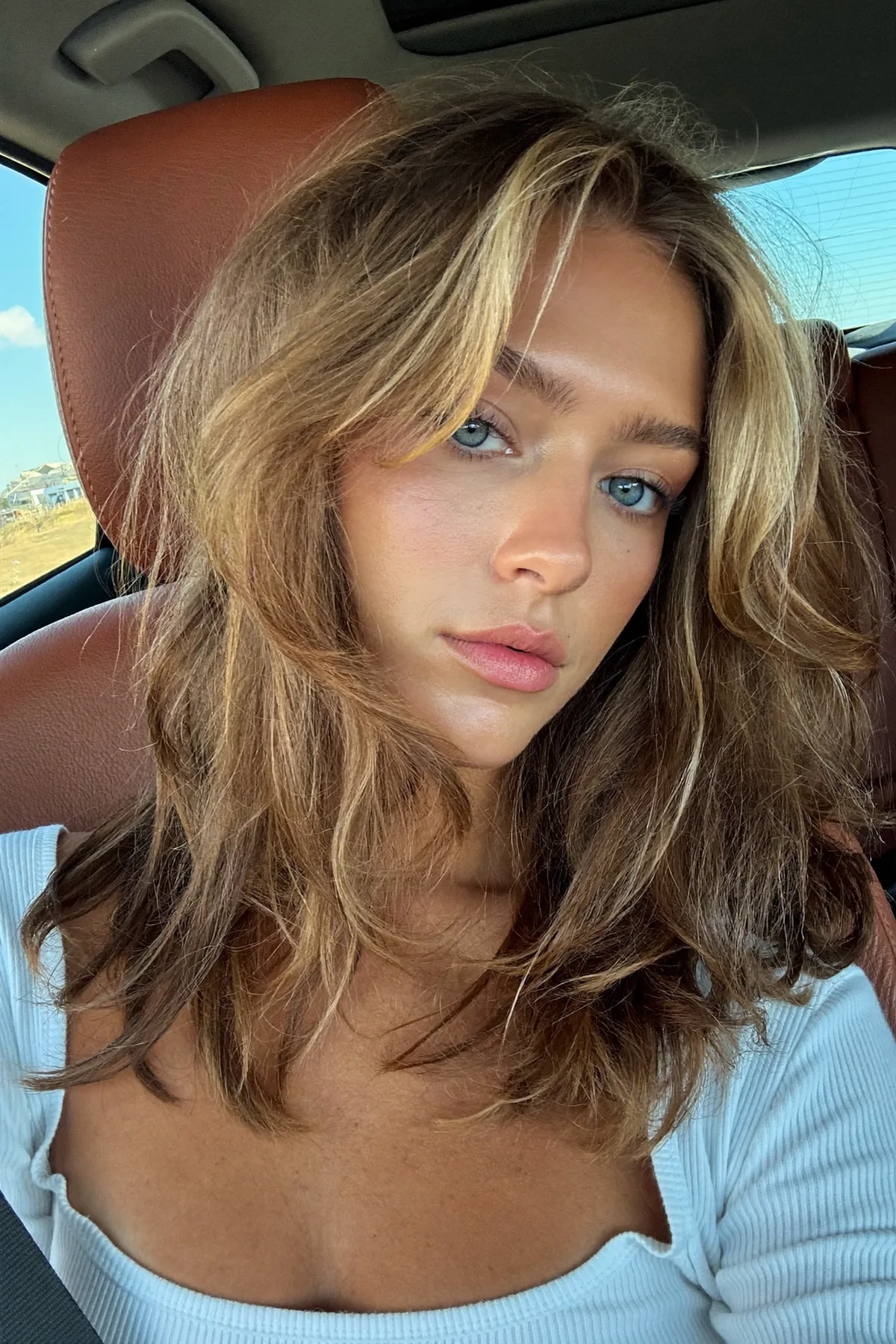Wavy Dark Blonde Lob with Blended Balayage and Curtain Bangs