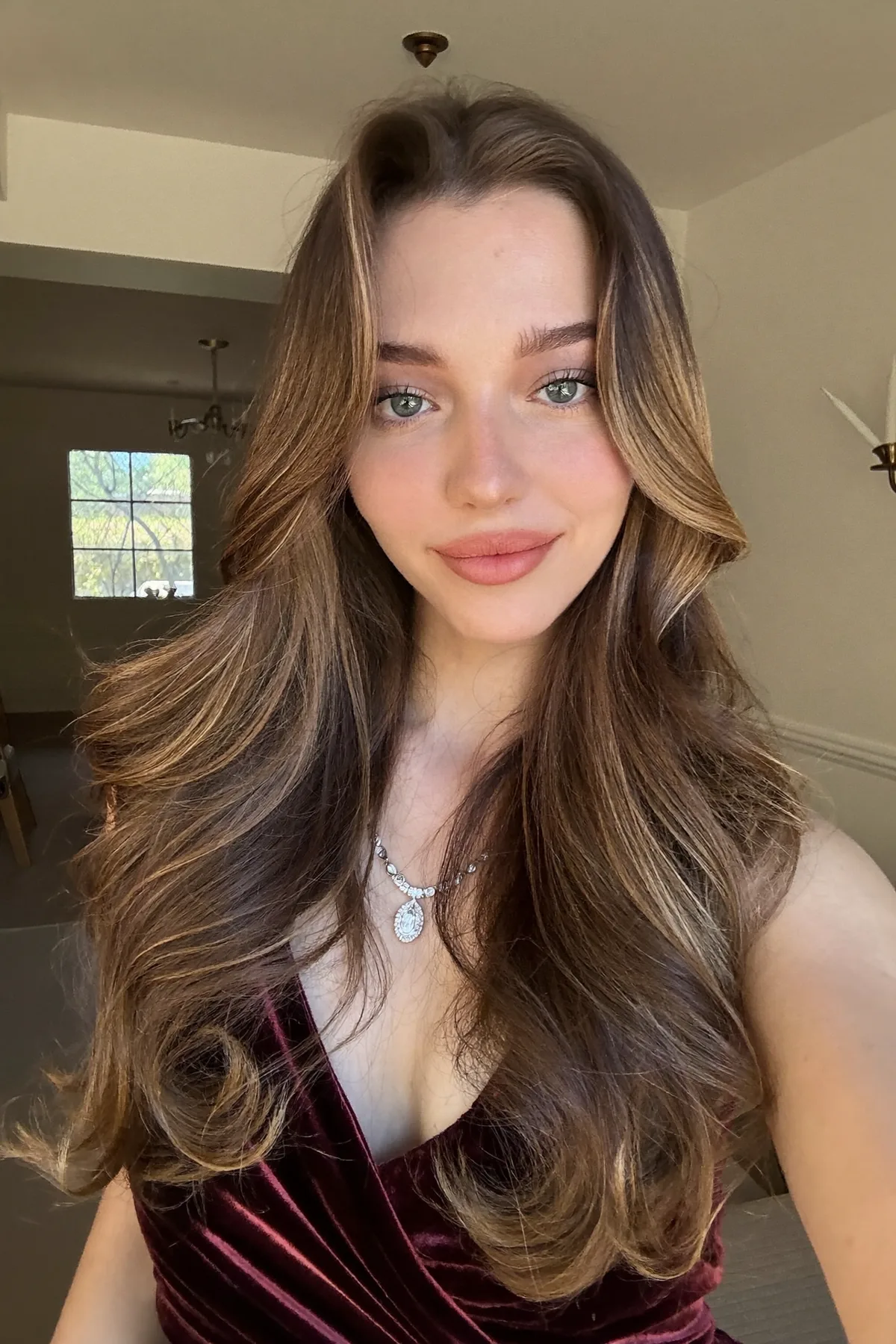Caramel Bronde Balayage on Long Layered Mid-Back Wavy Cut with Curtain Bangs